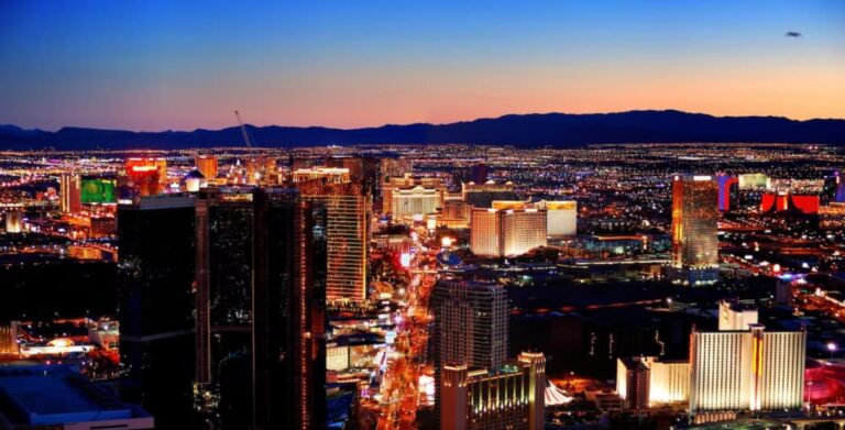 Twilight view over the Las Vegas Strip with illuminated high-rises and mountains in the background