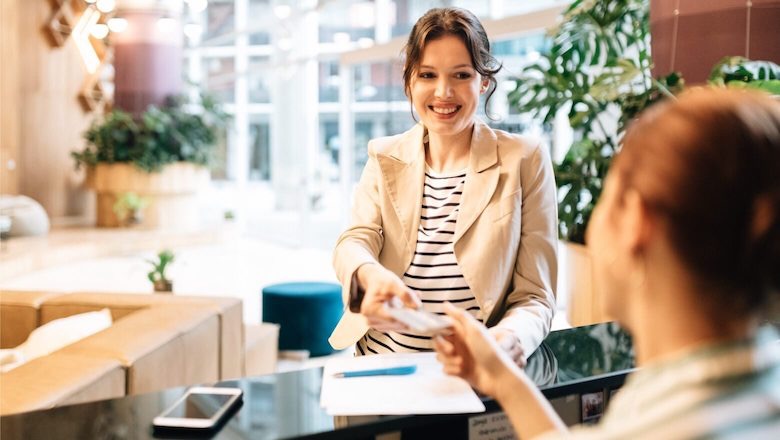 Girl gives a credit card to the hotel administrator