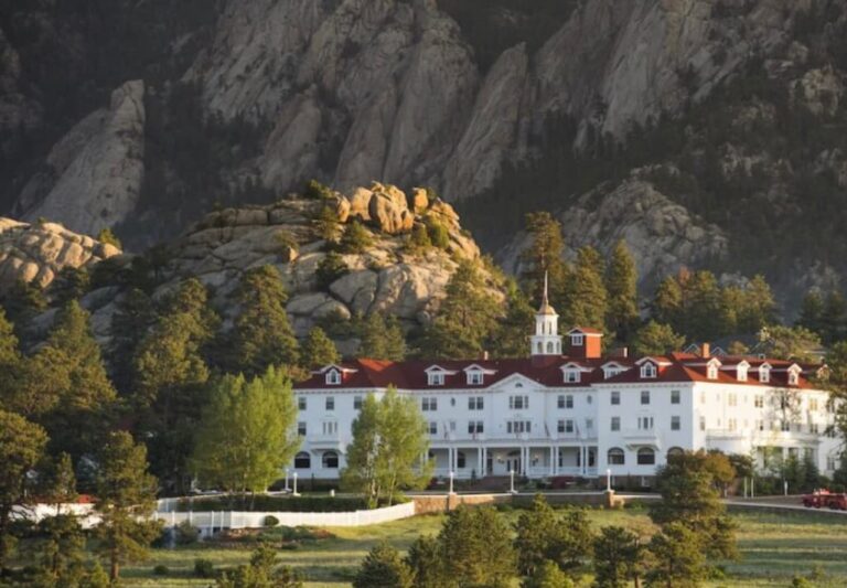 Stanley Hotel in Colorado against a backdrop of rocky hills and pine trees