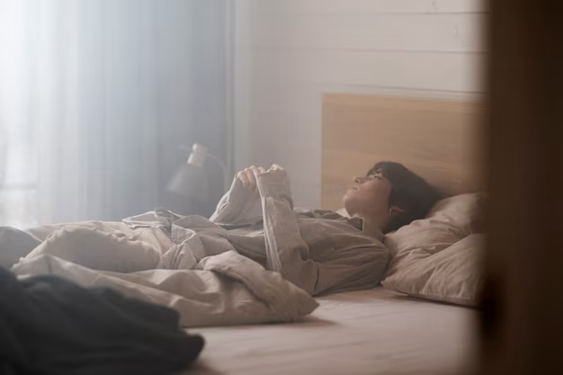 A guy lies in the bed of his hotel room