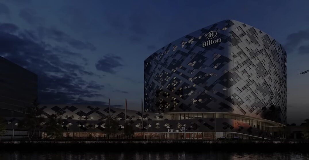 uniquely designed Hilton hotel with a patterned facade by a water body